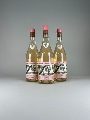 three bottles of wine are lined up on a white surface