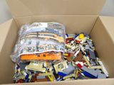 a cardboard box filled with legos and other toys