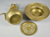 three brass objects are sitting on a white surface