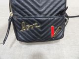 a black purse with a name on it sitting on a table