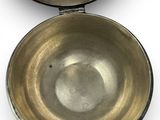 two metal bowls are sitting side by side on a white surface