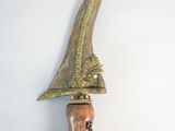 a wooden knife hanging on a wall next to a white wall