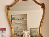 un miroir sur le mur au-dessus d'un lavabo dans une salle de bains