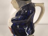 a blue and white pitcher with a black hat on it