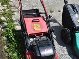 two lawn mowers sitting next to each other on the side of the road