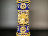 un vase bleu et or posé sur une table noire