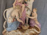 une figurine représentant une femme et deux enfants sur une vache