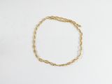 un bracelet en chaîne dorée sur un fond blanc