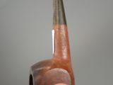 someone is holding a pipe in their right hand with a gray background