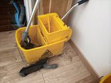 a mop and bucket sitting on the floor next to a wall