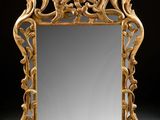 an ornately carved mirror is shown against a black background