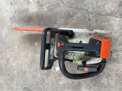 une tronçonneuse fixée à un mur en béton