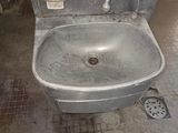 a dirty sink in a public restroom with a soap dispenser