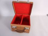 a brown suitcase with red linings on a white surface