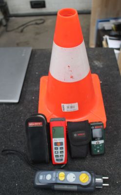 un cône de signalisation, une télécommande et d'autres appareils électroniques posés sur une table