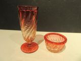 two glass vases sitting on a table next to each other