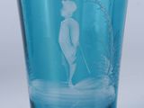 un verre en verre bleu sur lequel est représenté un homme