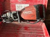 un outil rouge dans une boîte rouge, muni d'un cordon