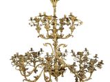 une image représentant un lustre en laiton orné de fleurs et de feuilles