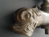 a metal faucet that has a bird head on it