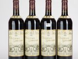quatre bouteilles de vin sont alignées sur une surface blanche