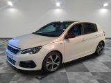une voiture blanche est garée dans une pièce au sol à carreaux