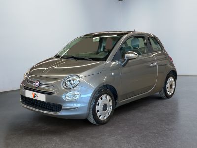 the small car is parked in a large room with a clock on the wall