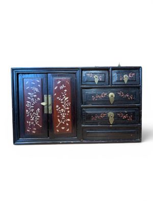 a black cabinet with a floral design on it