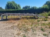 a wooden bridge that is sitting in the middle of a field