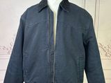 jacket on a mannequin stand in front of a white wall