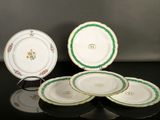 trois assiettes ornées de motifs verts et blancs reposent sur une surface noire