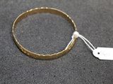 a close up of a gold bracelet with a tag on it