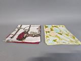 two napkins with birds and flowers on them sitting on a table