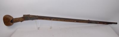 an old gun with a wooden handle on display on a white surface