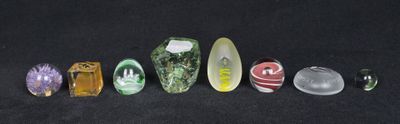 seven different types of glass beads on a black surface