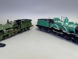 deux petits trains assis l'un à côté de l'autre sur une surface blanche