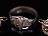 two rings and a ring with a flower on a black surface
