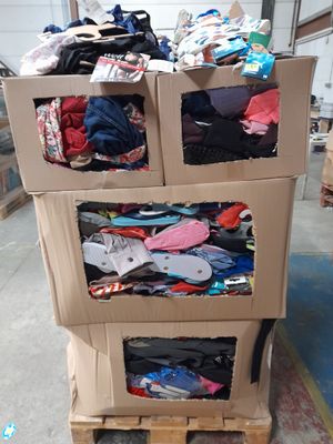 un chariot en carton sur lequel sont empilés des vêtements