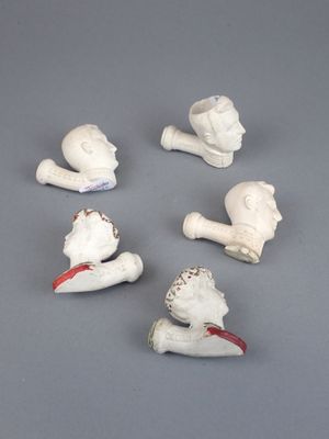 six figurines en céramique blanche représentant un homme et une femme, posées sur un fond gris