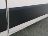 a white van with black stripes parked on the side of the road