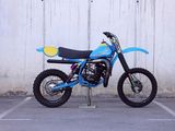 a blue dirt bike parked in a parking lot