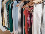 a lot of clothes hanging on a rack in a room