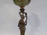 an image of a bronze and green vase with a woman holding a flower