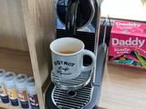une cafetière posée sur une étagère à côté d'une tasse