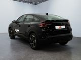 the rear end of a black car in a white room