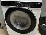 une machine à laver et un sèche-linge posés à même le sol dans une pièce