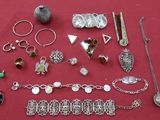 de nombreux bijoux en argent posés sur une table rouge