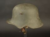 a green helmet on a clear stand on a black background