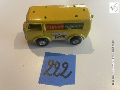 un petit camion jaune en plastique posé à côté d'une feuille de papier bleue
