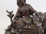 a bronze statue of a woman sitting on a bench with a dog